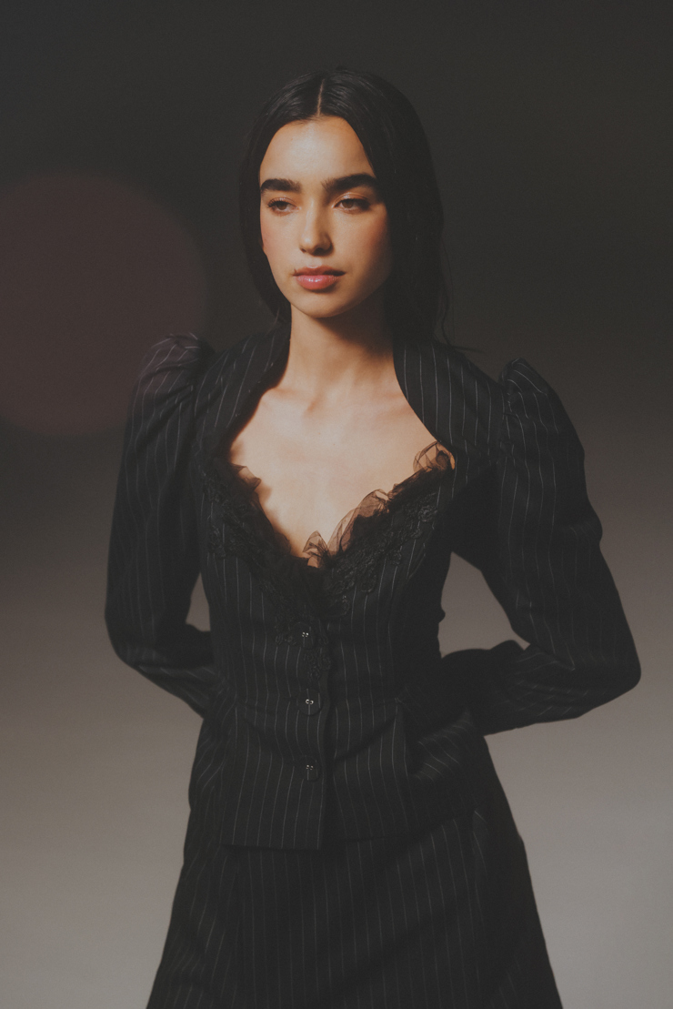 Halvkroppsbild på Sofia Monroy i en svart klänning med kritstrecksränder.